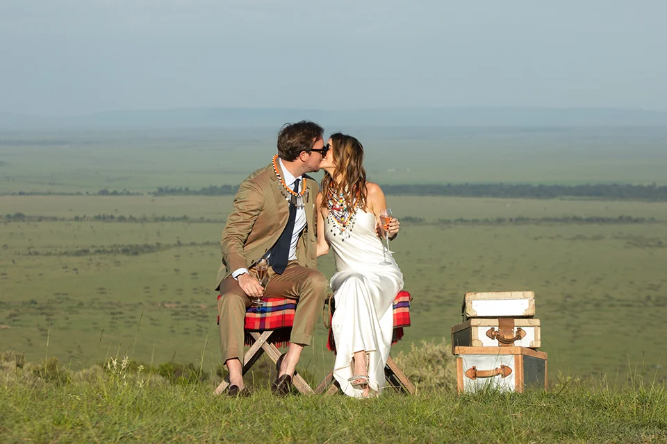 Couple celebrating with champagne overlooking the Maasai Mara from Angama Mara