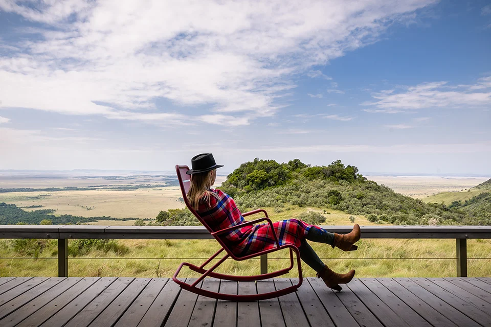 Guest relaxing on the deck at Angama Mara overlooking the Great Rift Valley