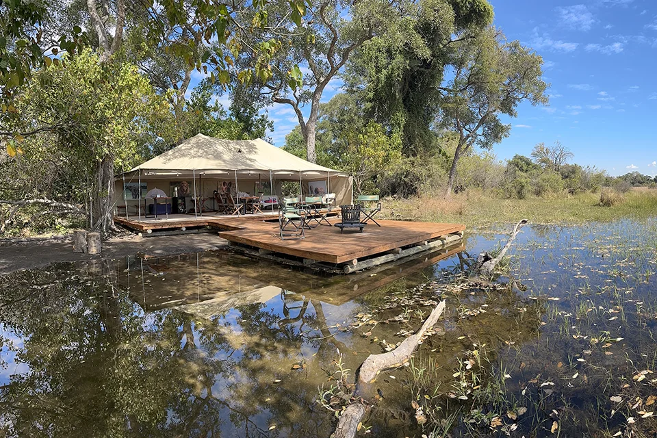 Safari camp tent and wooden deck overlooking the waterways of the Okavango Delta