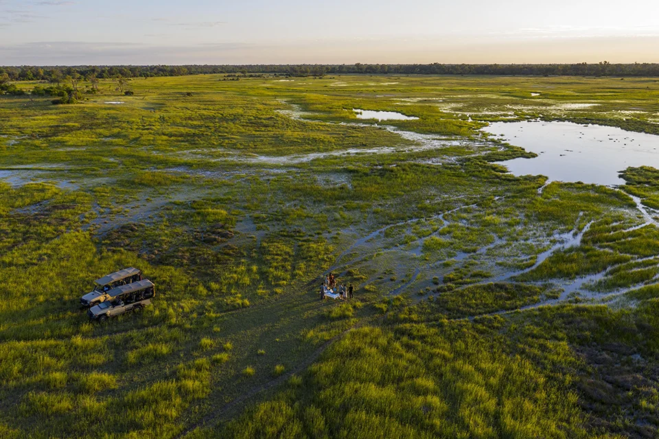 Aerial view of a safari picnic beside seasonal floodplains in Botswana's Okavango Delta