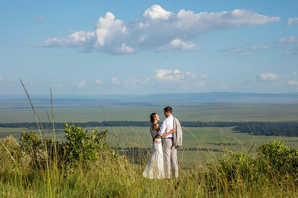 Couple celebrating their wedding with panoramic views over the Maasai Mara at Angama Mara, Kenya