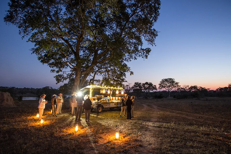ncentive safari group gathering for evening drinks beside a mobile bar in the African bush at Chitwa House, South Africa