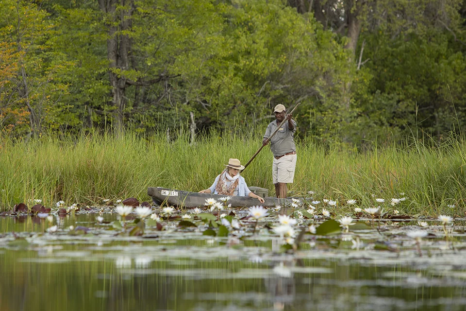 Guest exploring the Okavango Delta by mokoro with a guide at Sango Safari Camp