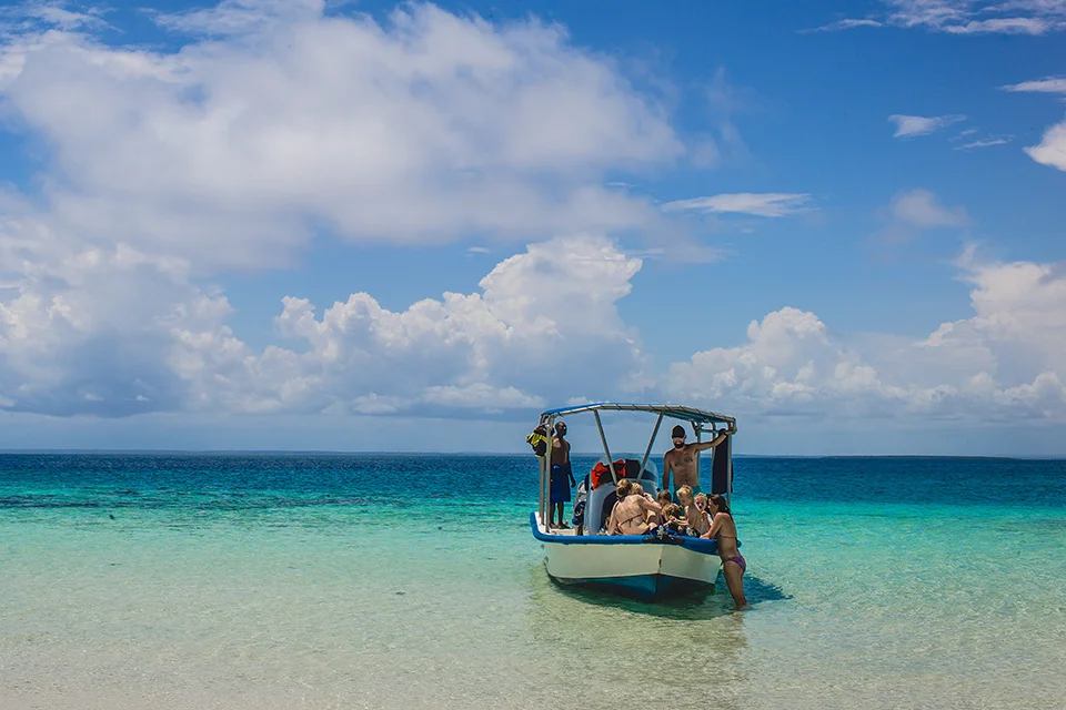 Guests arriving by boat on a pristine beach off the coast of Diani Beach, Kenya