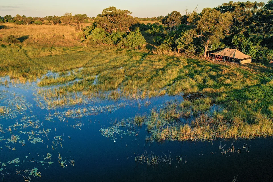 Aerial view of a luxury safari camp overlooking seasonal floodplains in Botswana's Okavango Delta