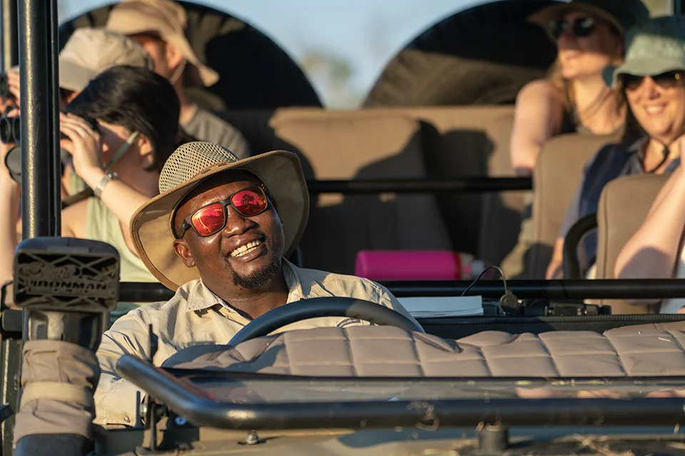 Safari guide and guests enjoying a game drive through Botswana's Okavango Delta