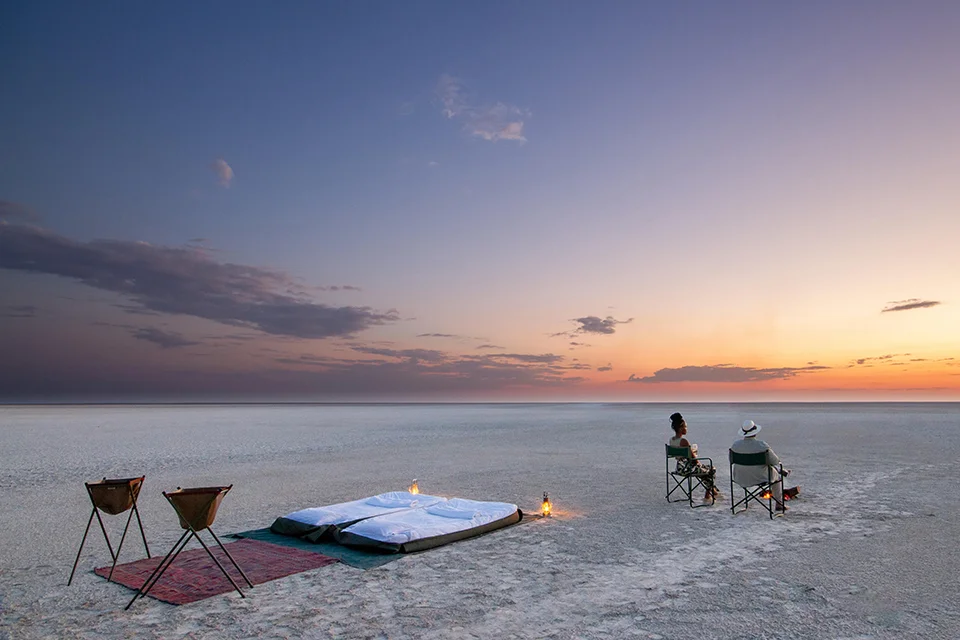 Guests enjoying a sunset sleep-out experience on Botswana’s Makgadikgadi Salt Pans