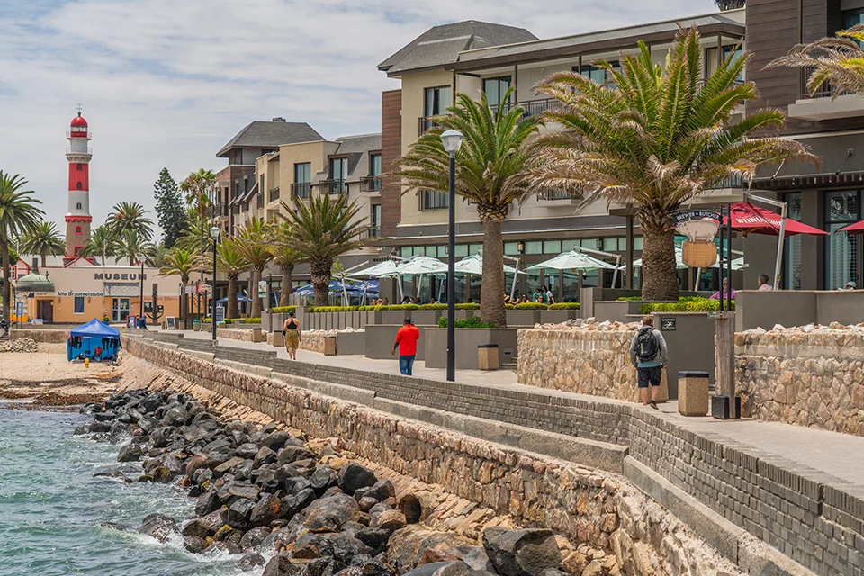 Waterfront promenade in Swakopmund, Namibia, with palm trees and the historic lighthouse