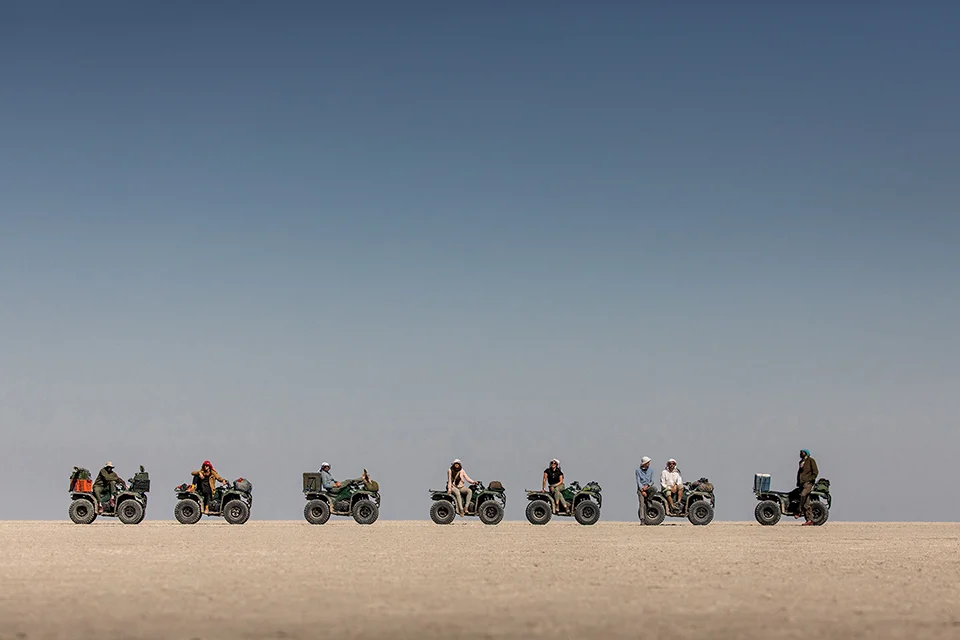 Guests quad biking across the vast Makgadikgadi Salt Pans near Camp Kalahari, Botswana