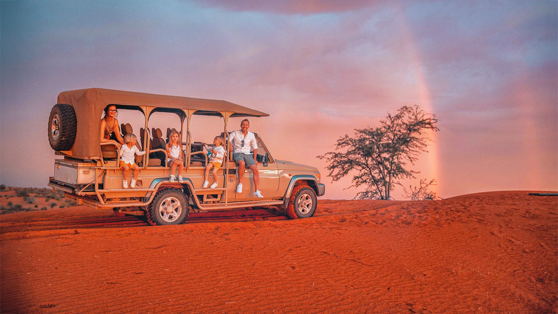 Family enjoying a sunset safari in an open game-drive vehicle at Kalahari Anib Lodge, Namibia