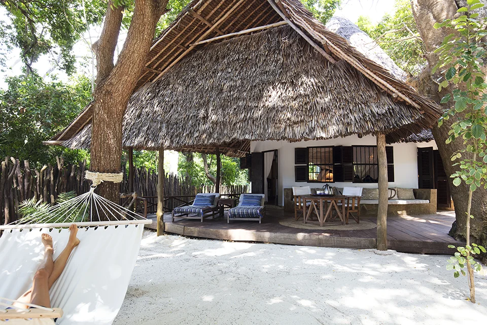 Beachfront cottage at Kinondo Kwetu on Kenya’s Diani Beach, featuring a private hammock, shaded veranda and relaxed Indian Ocean island-style setting