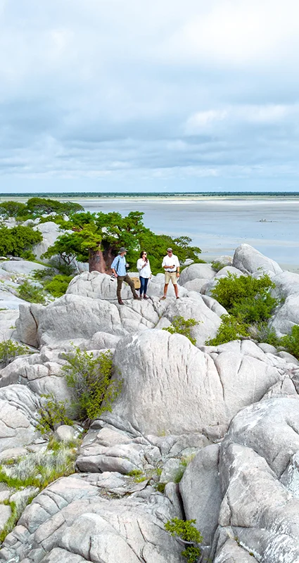 Guests exploring rocky outcrops overlooking a vast salt pan landscape